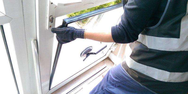 PVC pencere kanadında cam değişimi yapan eldivenli çalışan